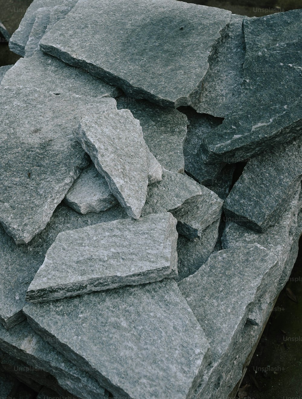 a pile of gray rocks sitting on top of a sidewalk