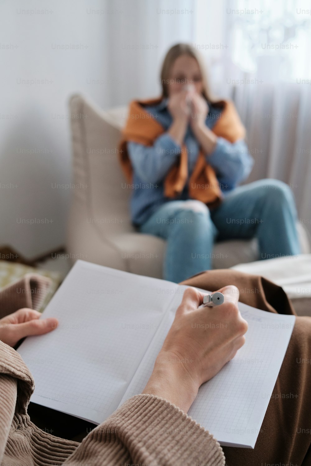 a woman sitting in a chair holding a pen and paper