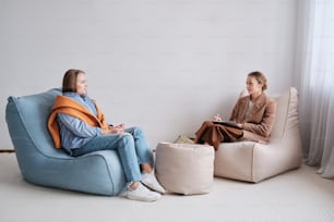 Due donne sedute su sacchi di fagioli in una stanza