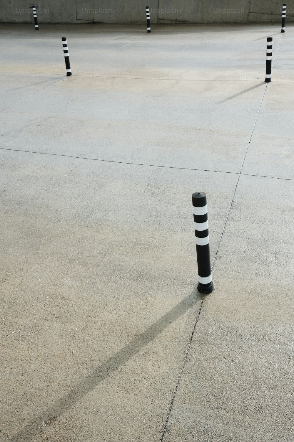 a group of black and white poles in a parking lot