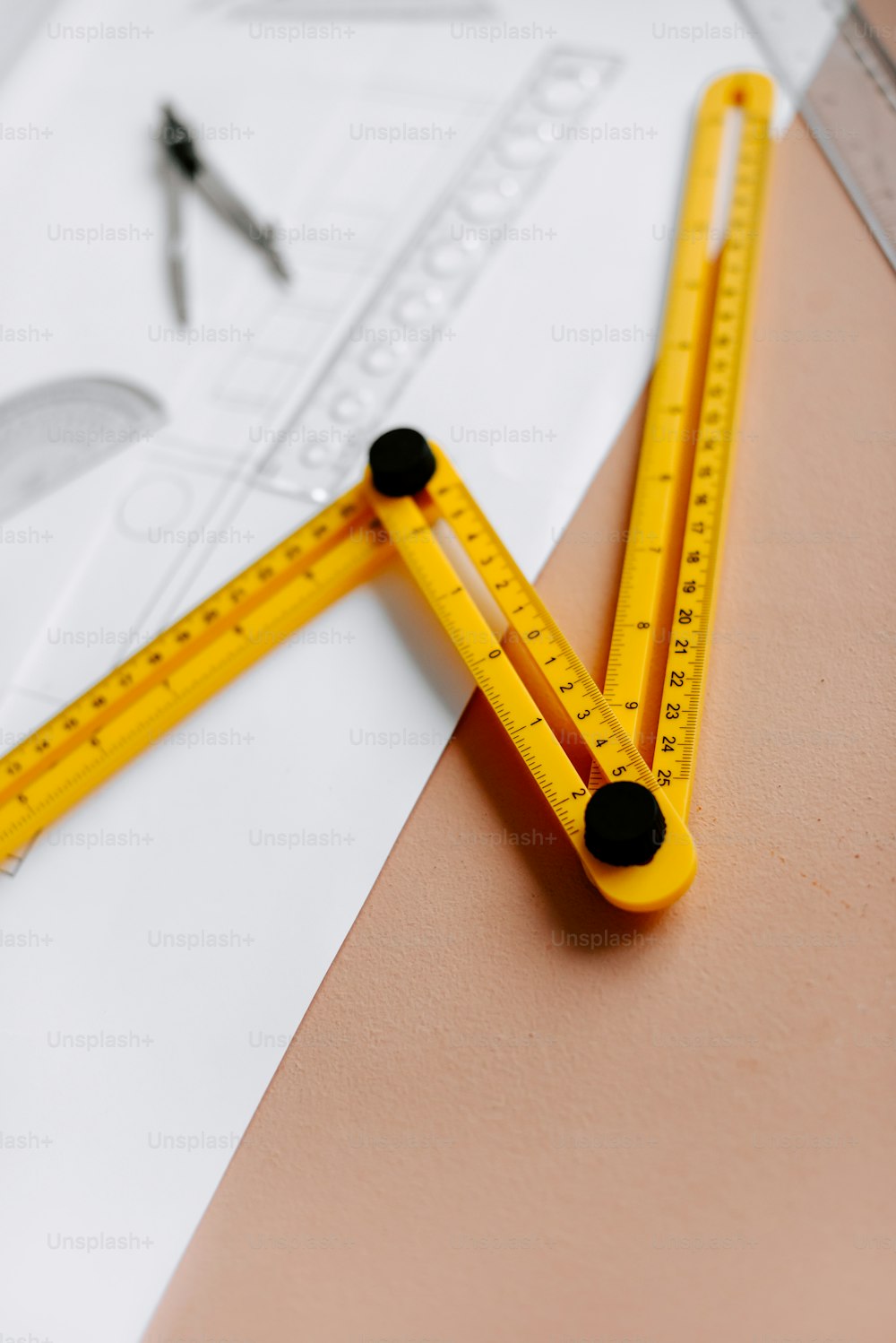 a pair of yellow rulers sitting on top of a piece of paper