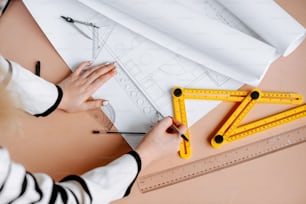 a woman is working on some construction drawings