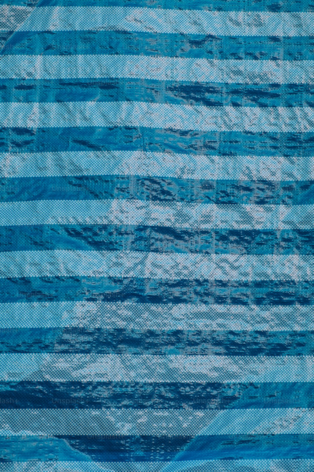 a blue and white striped quilt on a bed