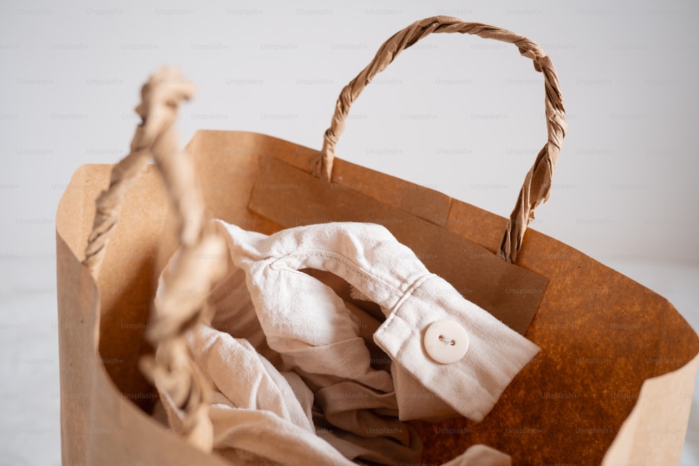 a brown paper bag with a white shirt inside of it