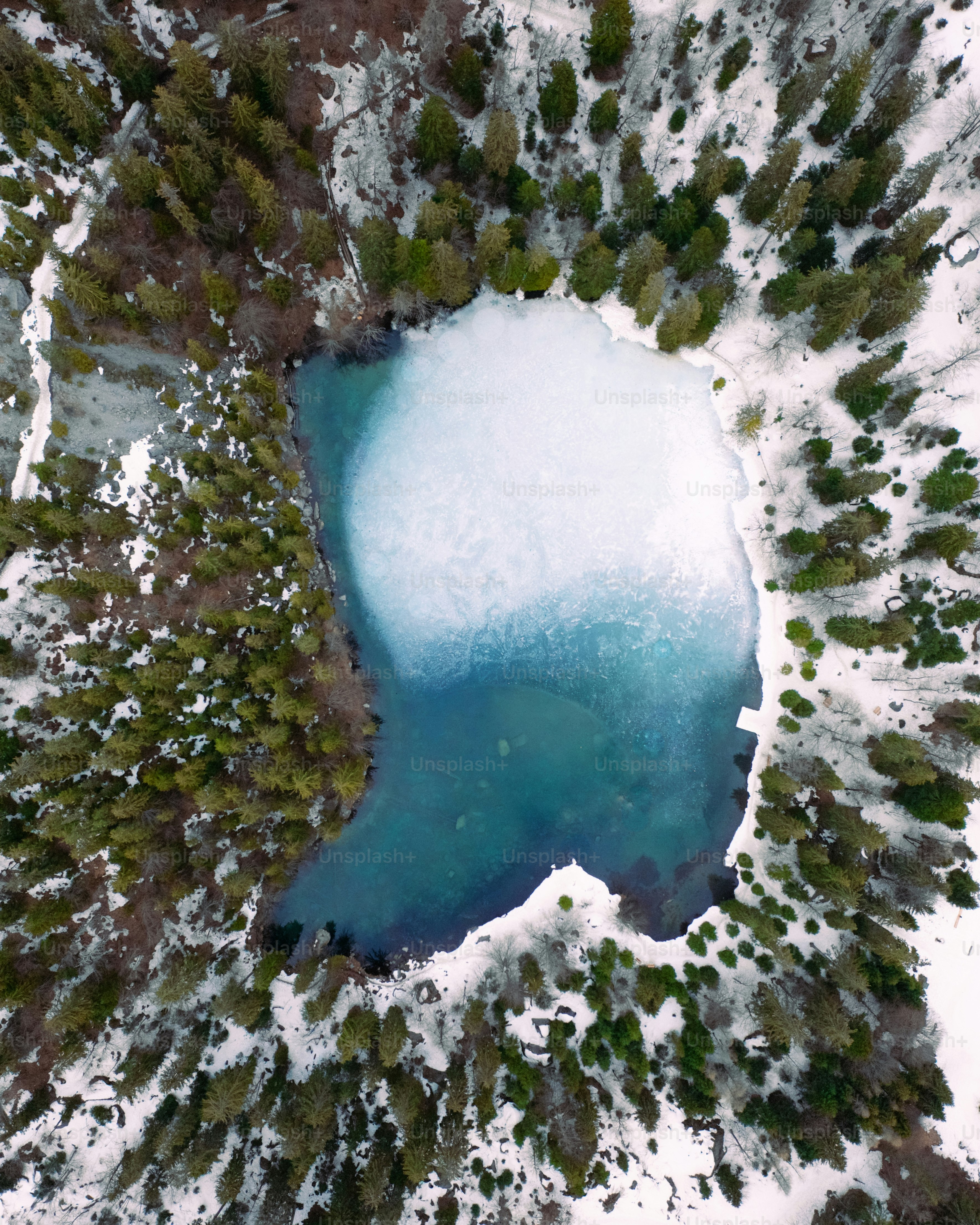 une vue aérienne d’un lac entouré de neige