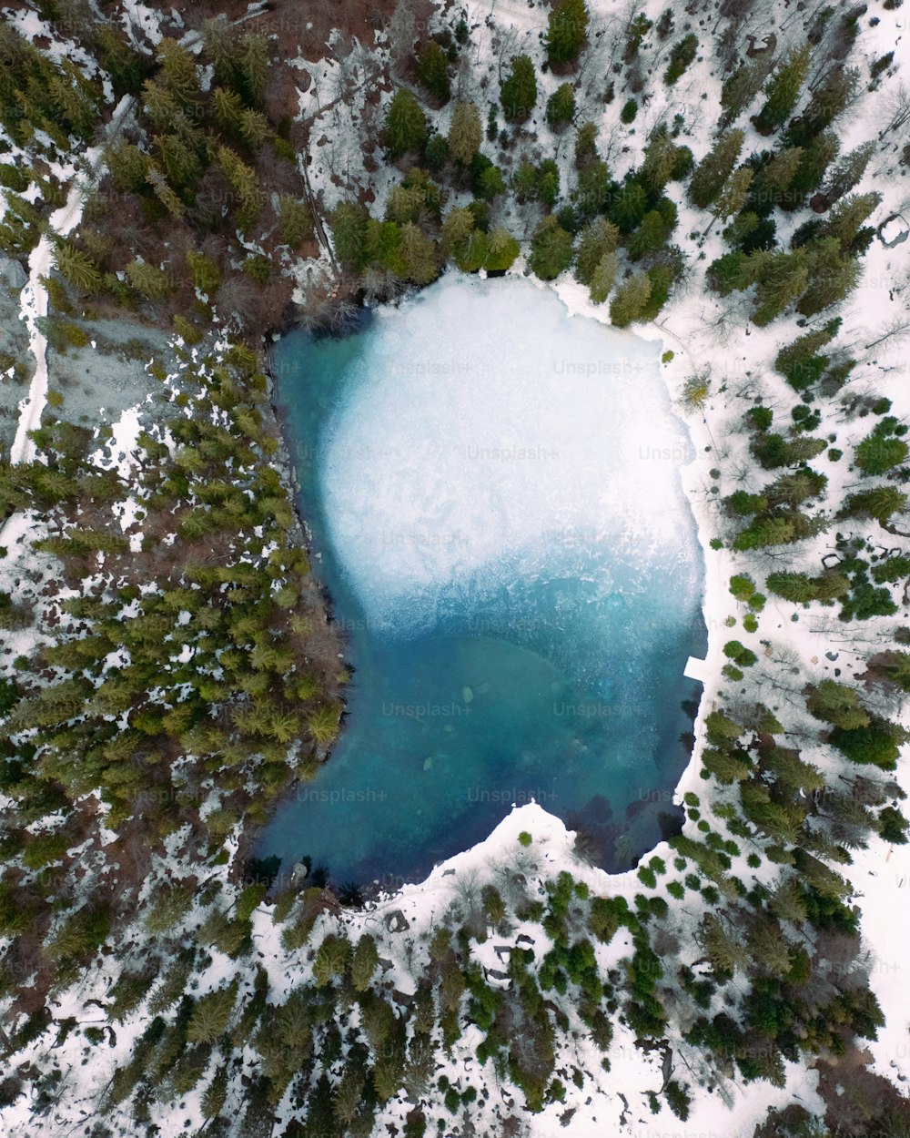 uma vista aérea de um lago cercado por neve