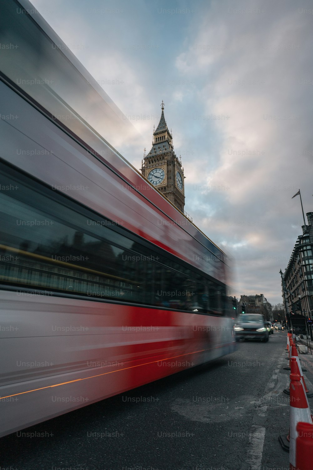 ein rot-weißer Doppeldeckerbus und ein Uhrturm