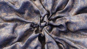 a close up of a blue fabric with gold speckles