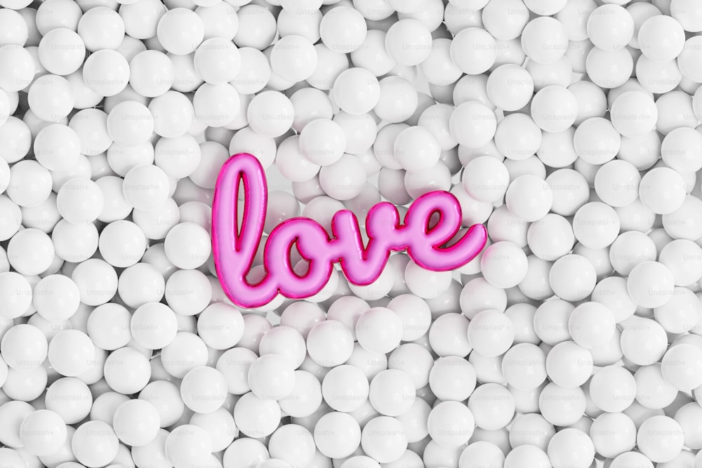 a pink love word surrounded by white balls