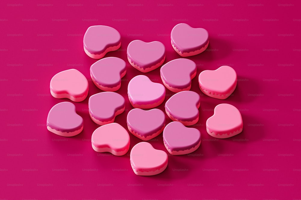 a pile of pink heart shaped cookies on a pink background