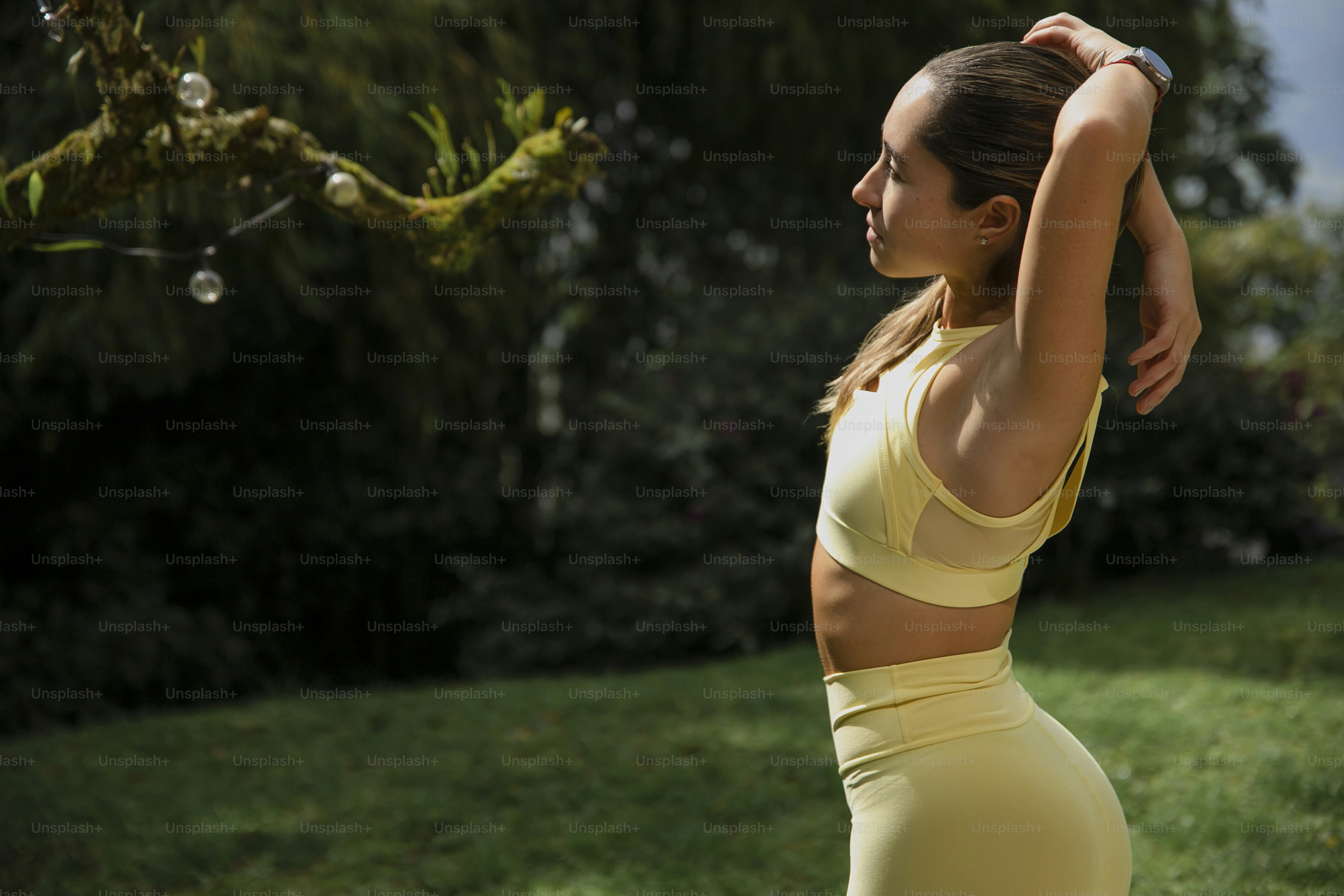 a woman in a yellow sports bra top and leggings