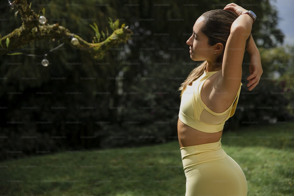 uma mulher em um top amarelo do sutiã esportivo e leggings