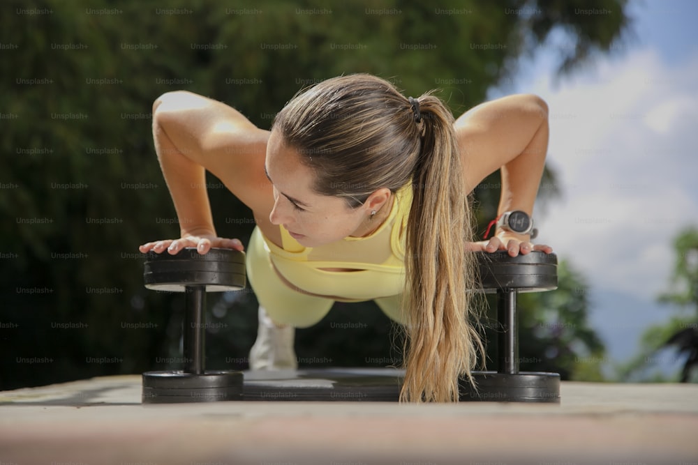 a woman is doing push ups on a bench