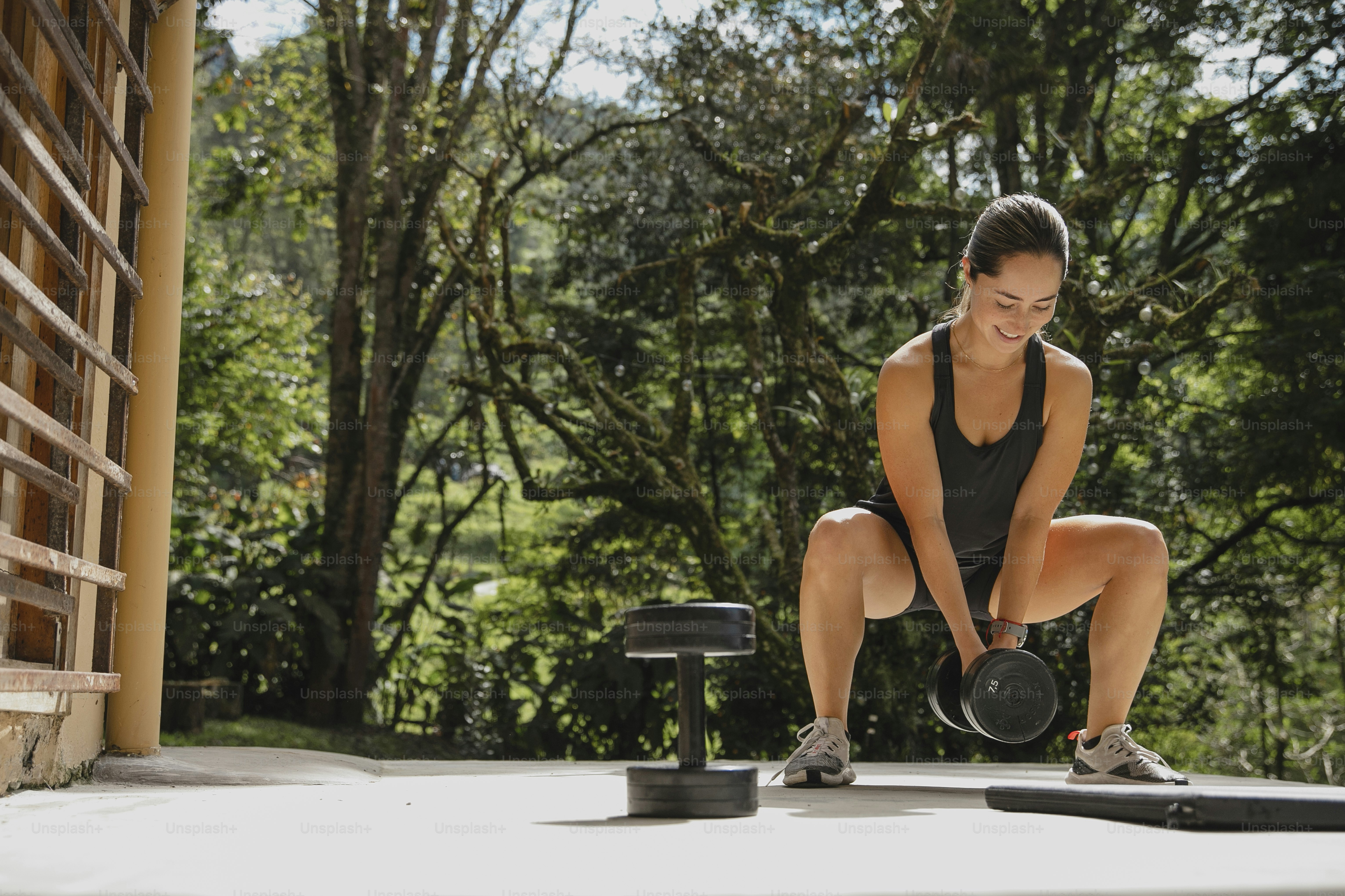 Una mujer en cuclillas con una tetera frente a ella