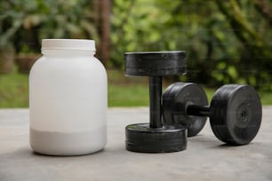 a bottle of water next to a pair of dumbbells