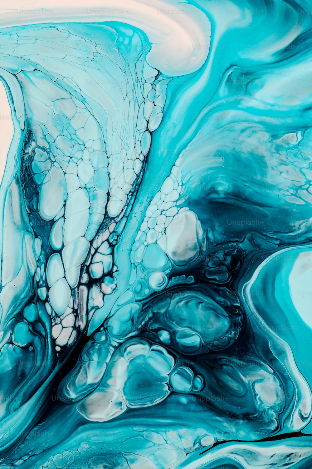 a close up of a blue and white fluid painting