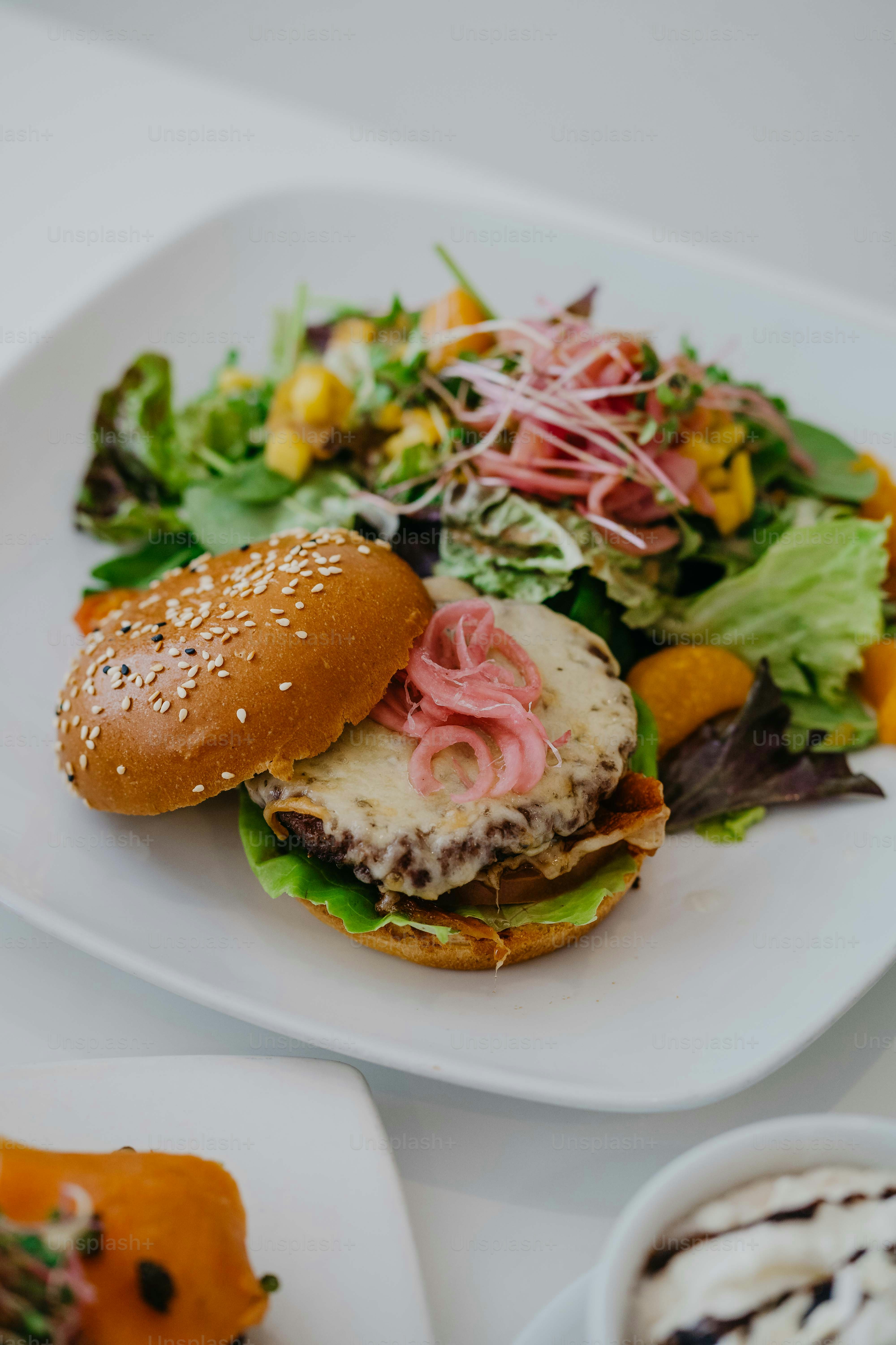 a white plate topped with a sandwich and salad