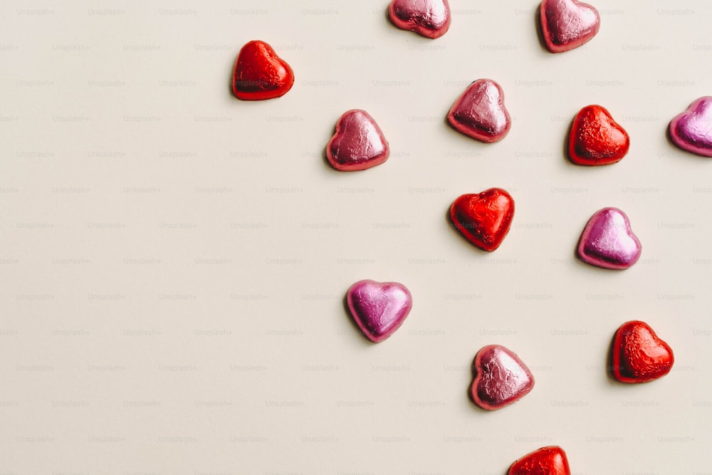Un grupo de caramelos en forma de corazón sobre una superficie blanca