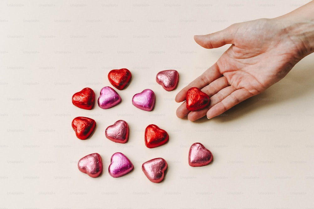 a hand reaching for a heart shaped candy