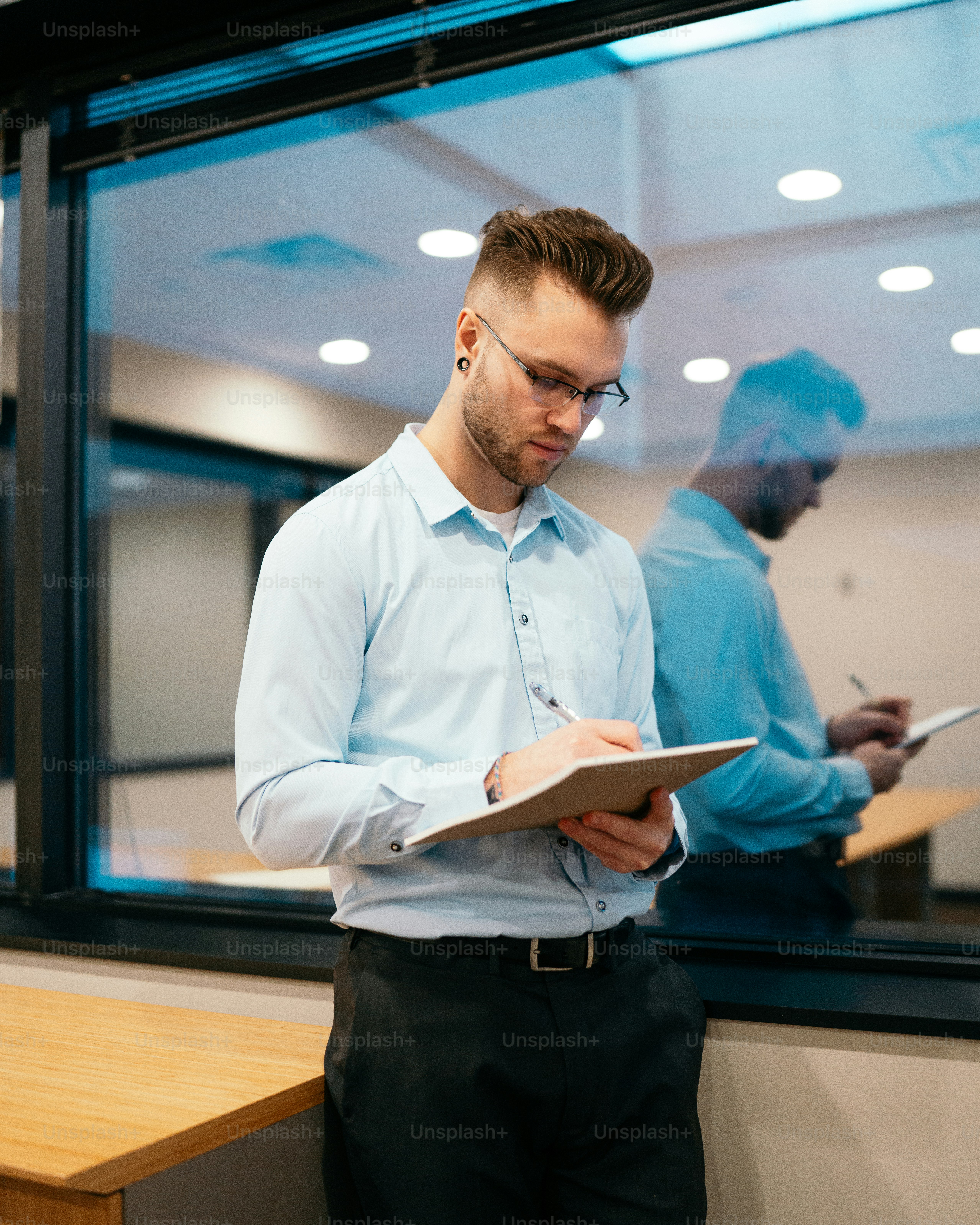 a man standing in front of a window holding a clipboard