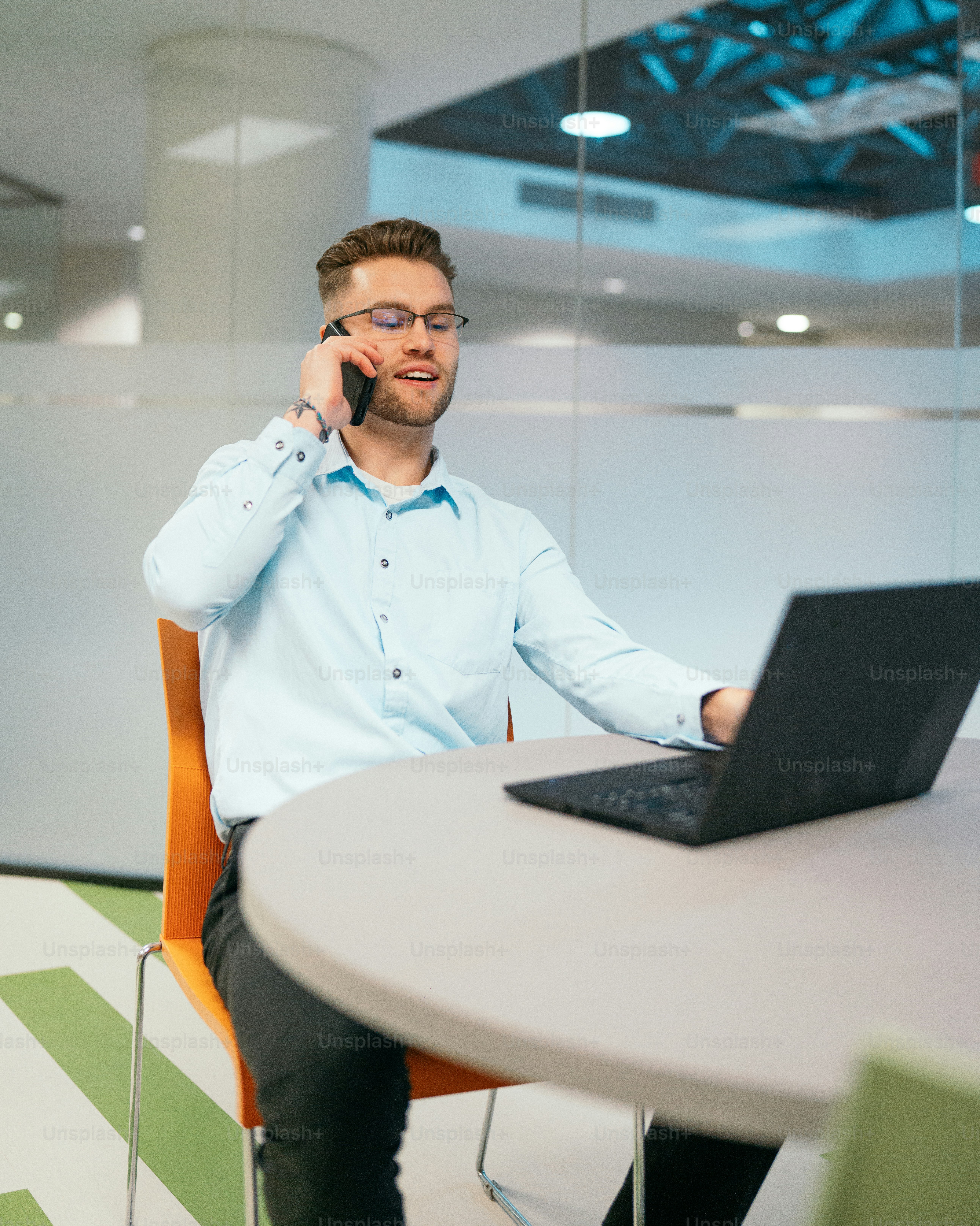 a man sitting at a table talking on a cell phone