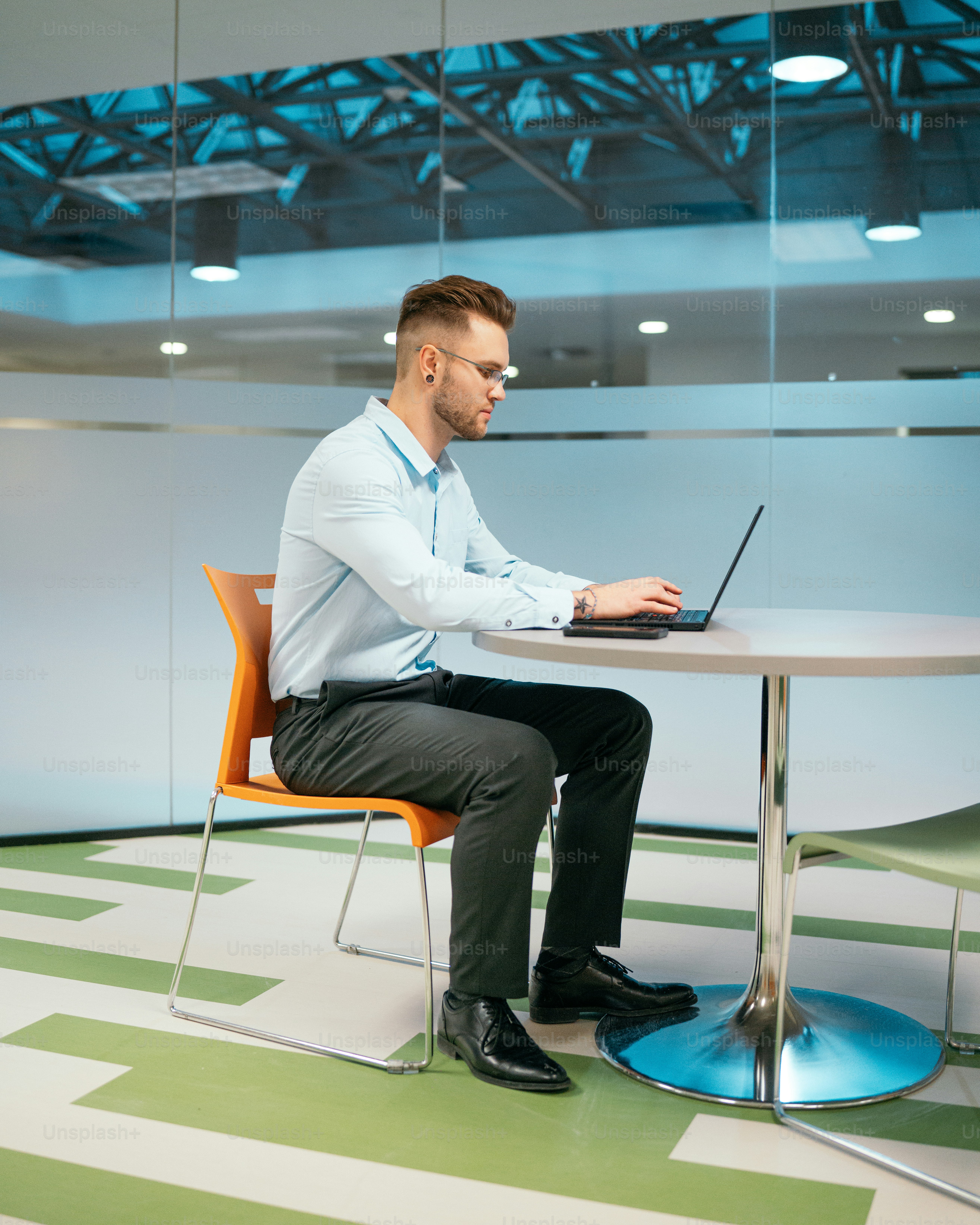 a man sitting at a table using a laptop computer