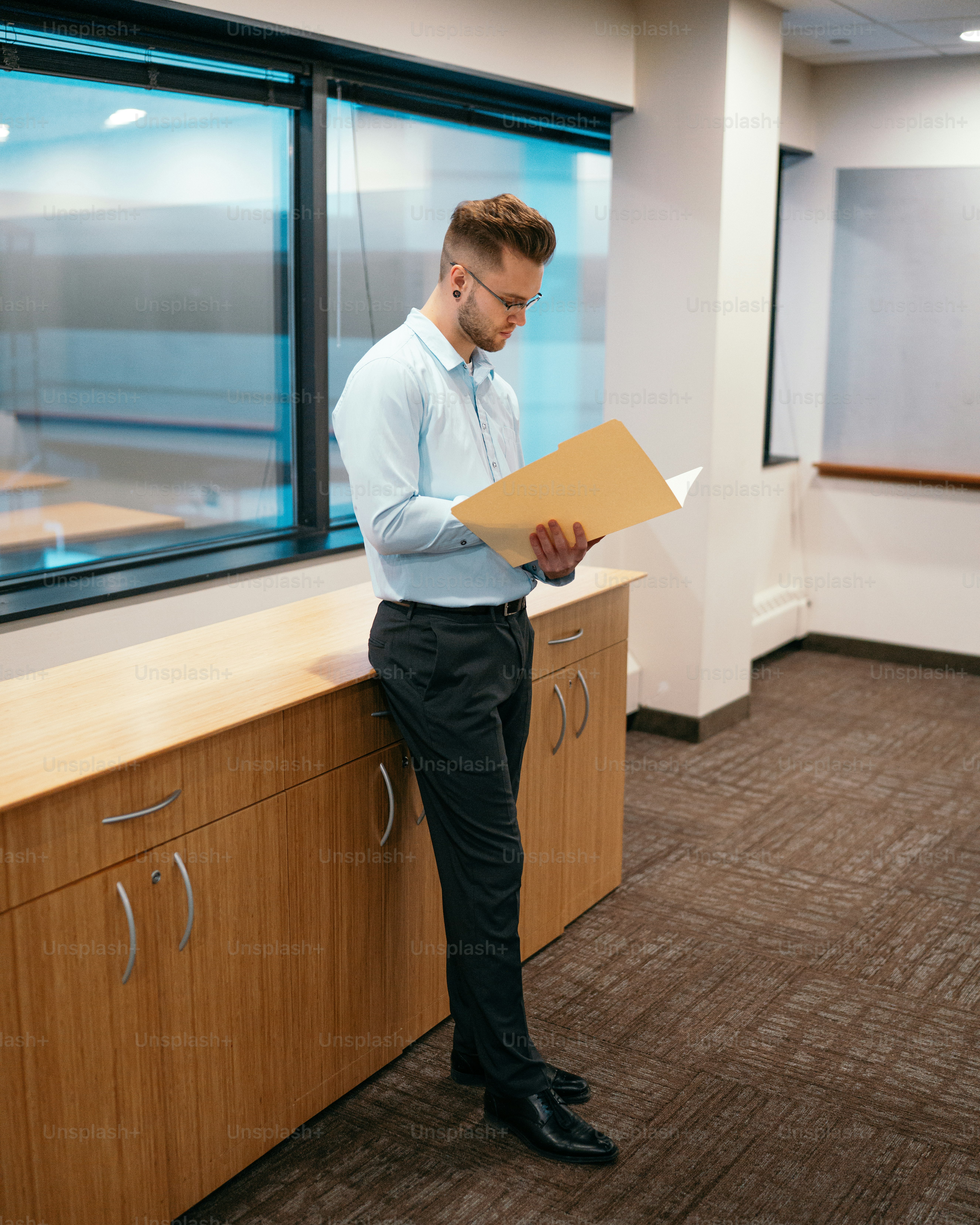 a man in a dress shirt and tie holding a folder
