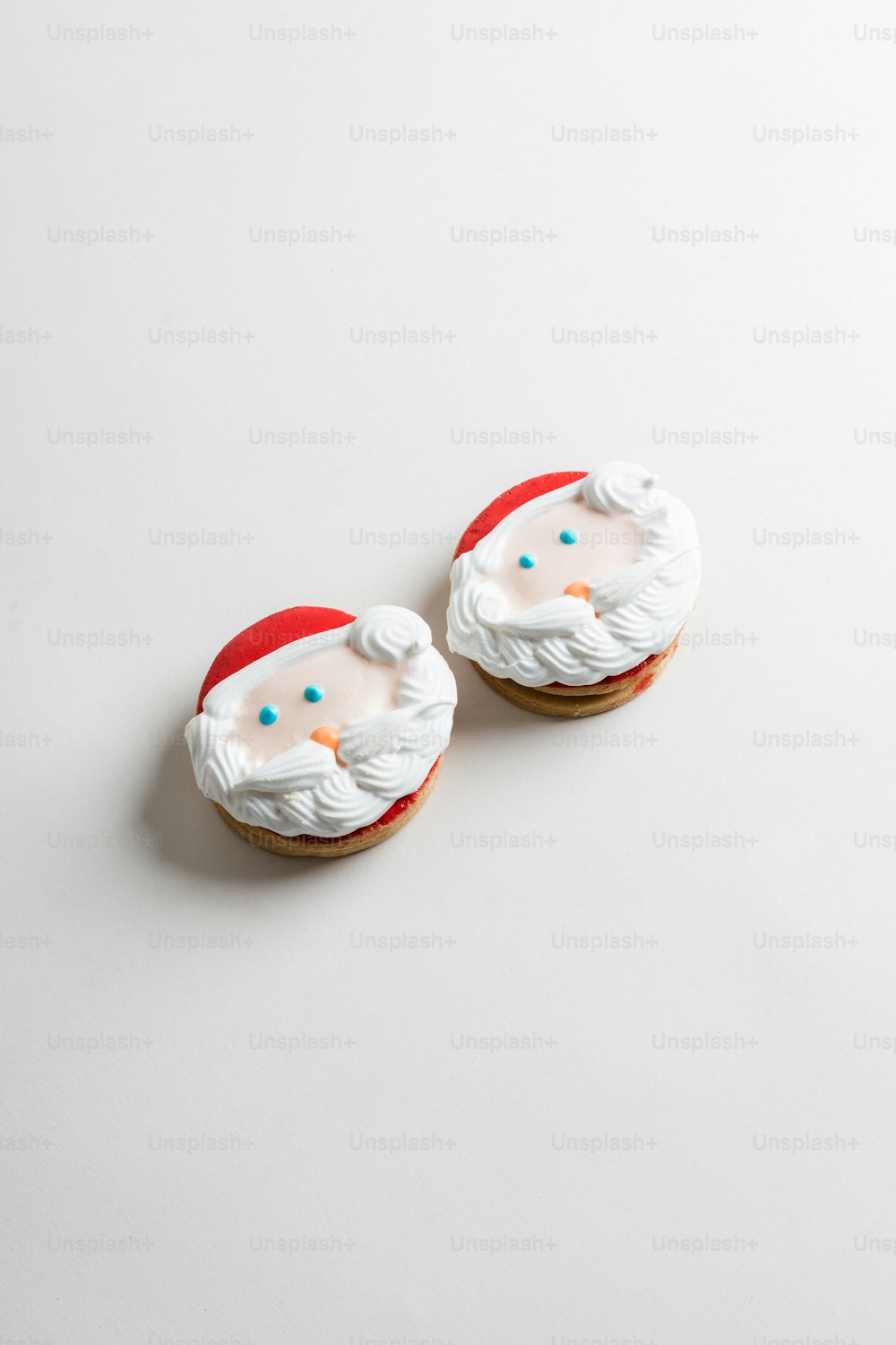 two decorated cookies sitting on top of a white table