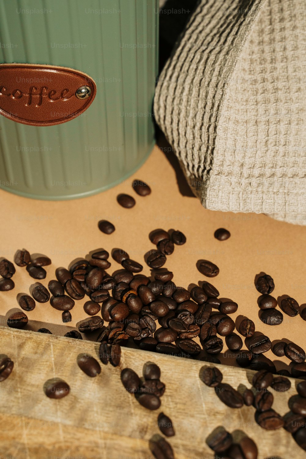 a pile of coffee beans sitting next to a cup of coffee