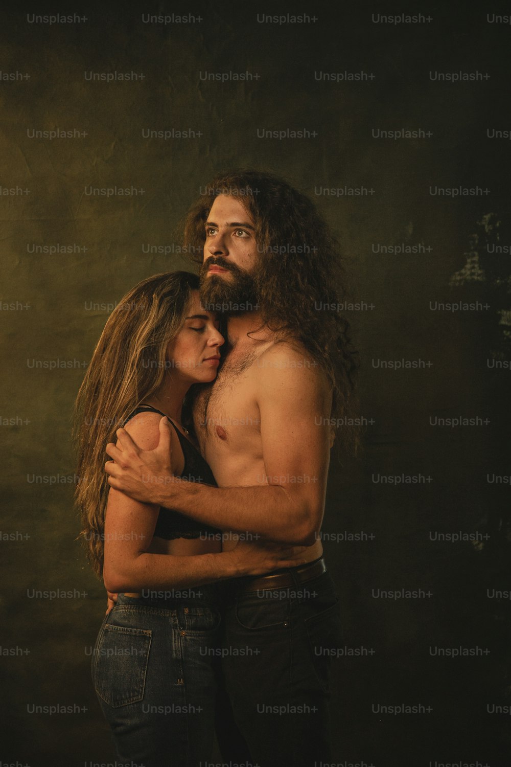 a man with long hair hugging a woman
