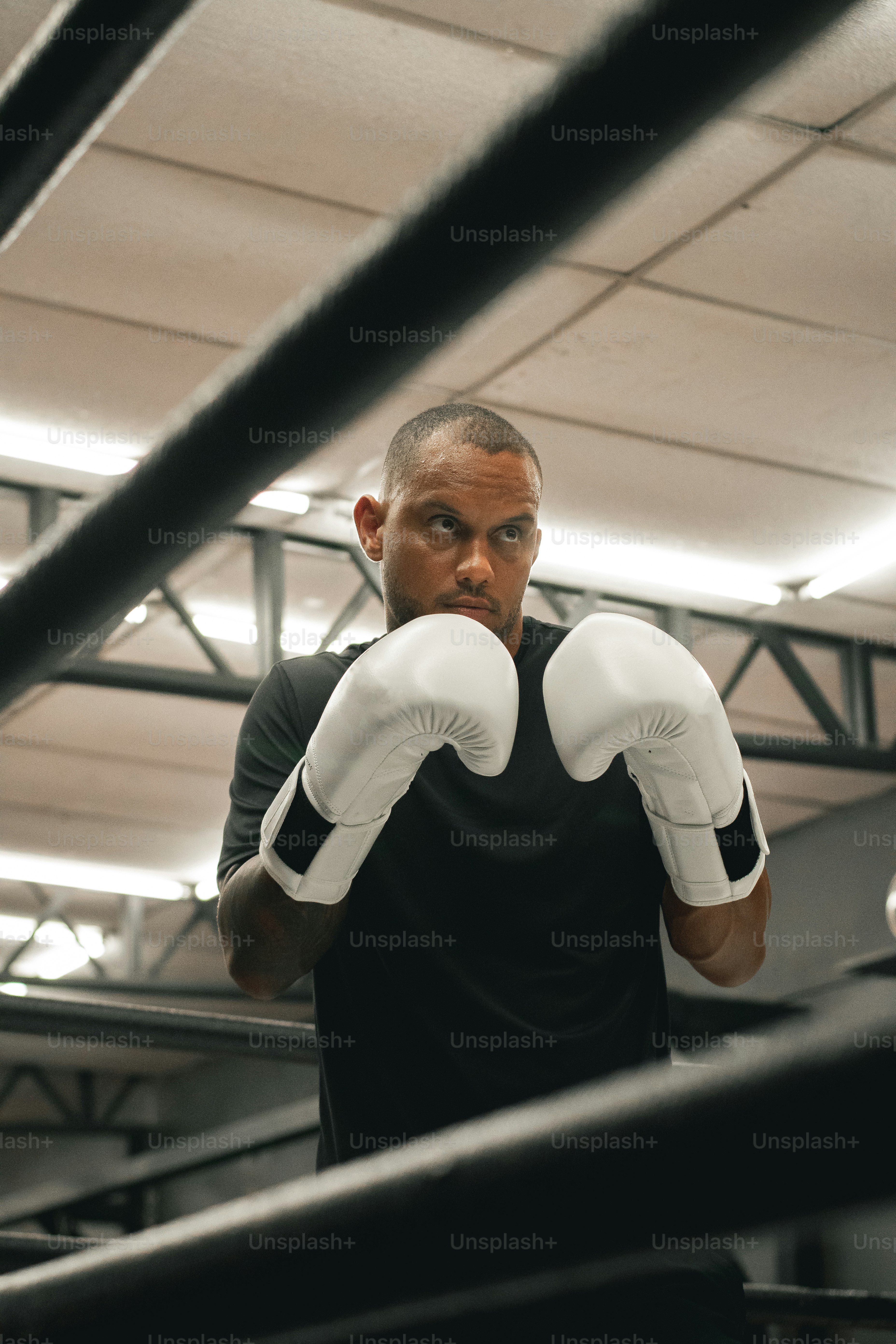 Ein Mann in schwarzem Hemd und weißen Boxhandschuhen