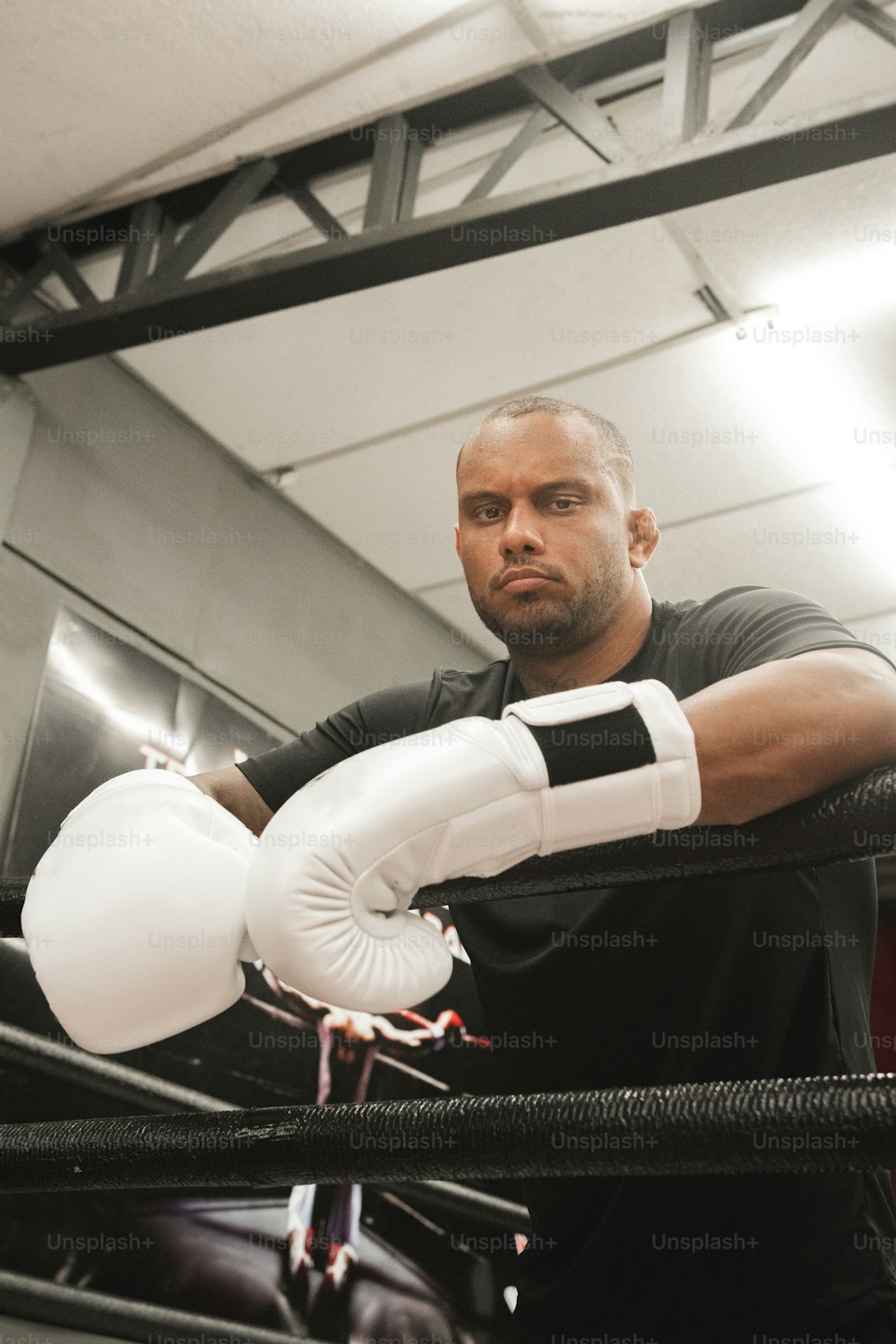 Un hombre parado en un ring de boxeo sosteniendo un guante blanco