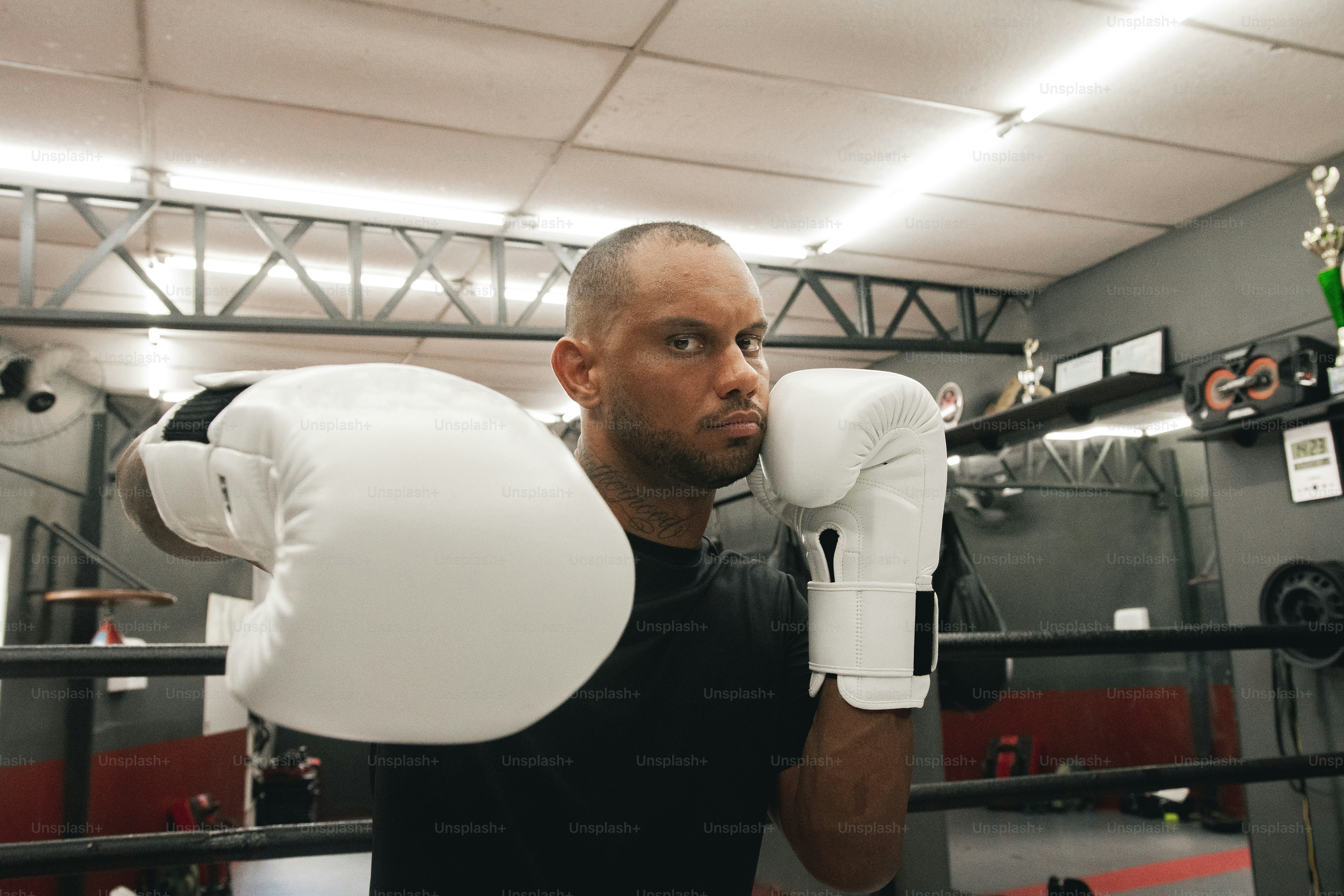 Ein Mann in schwarzem Hemd und weißen Boxhandschuhen