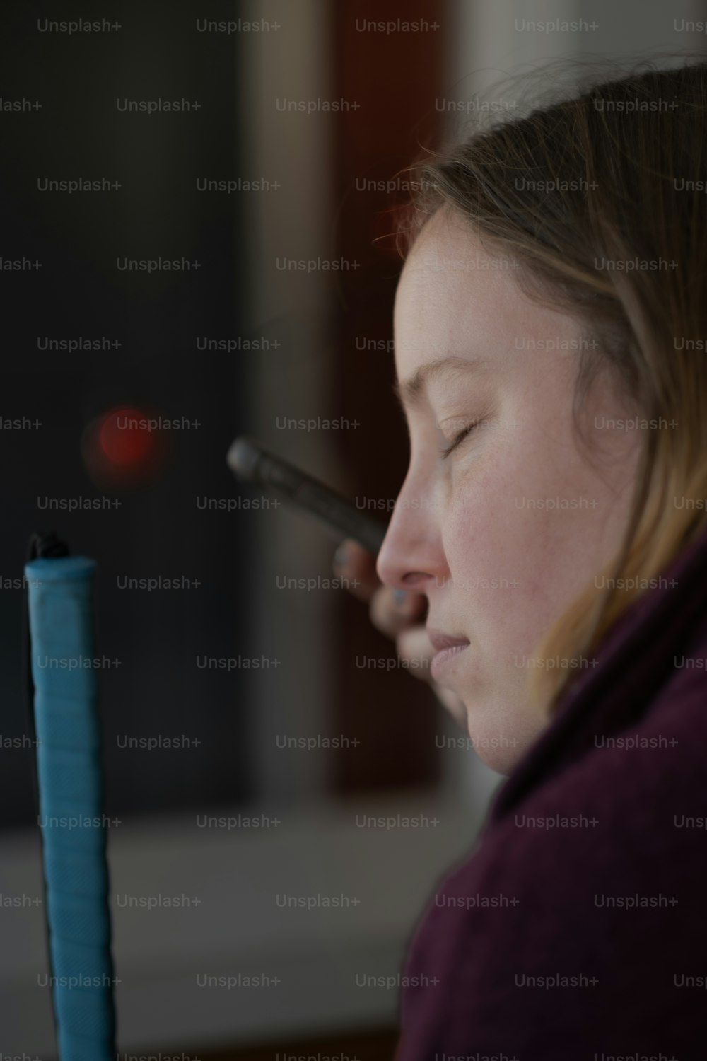 Una donna con gli occhi chiusi che tiene un cellulare all'orecchio
