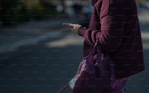 Una mujer sosteniendo un teléfono celular en la mano