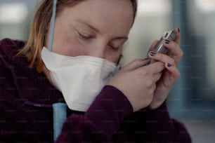 a woman wearing a face mask using a cell phone