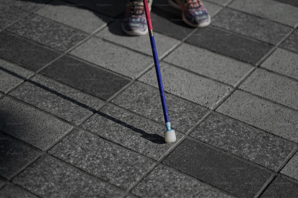uma pessoa em pé em uma calçada com uma escova de dentes na mão
