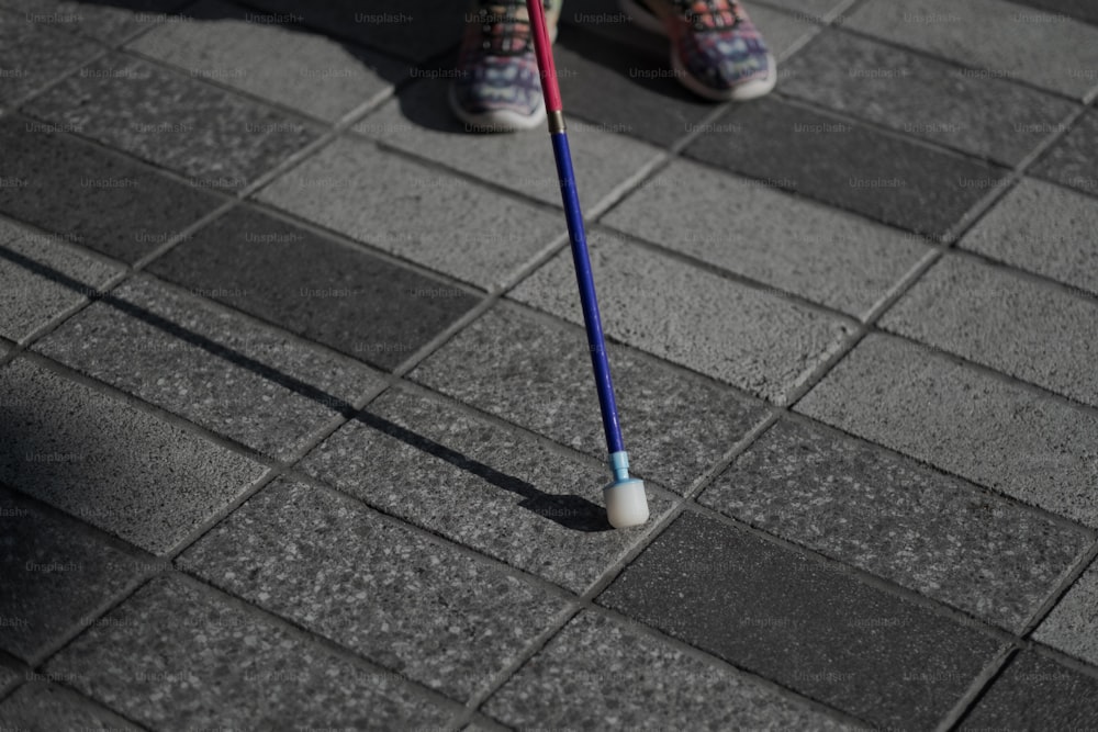 Una persona parada en una acera con un cepillo de dientes en la mano