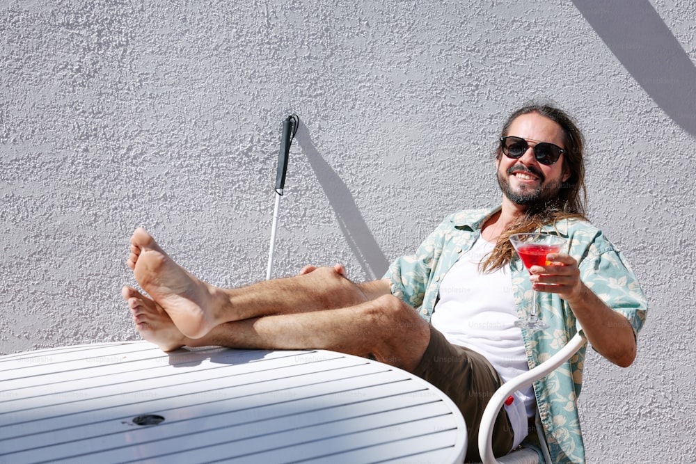 a man sitting on a table holding a drink