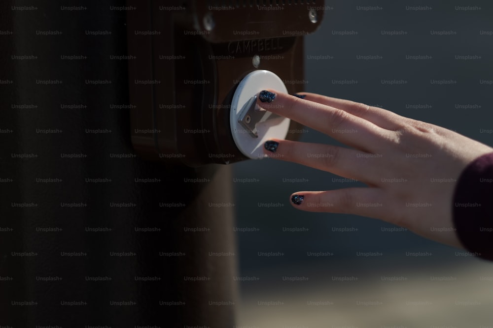 a woman's hand is pressing a button on a brown suitcase