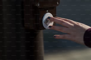 Die Hand einer Frau drückt einen Knopf an einem braunen Koffer