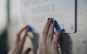 a person is writing on a sign on a wall