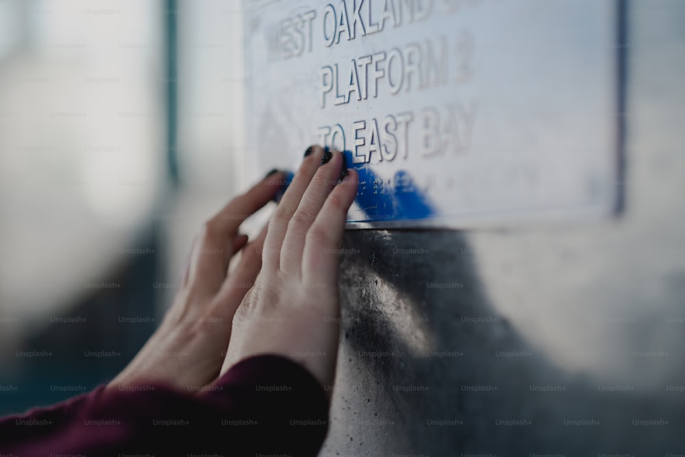 a person writing on a sign on a wall