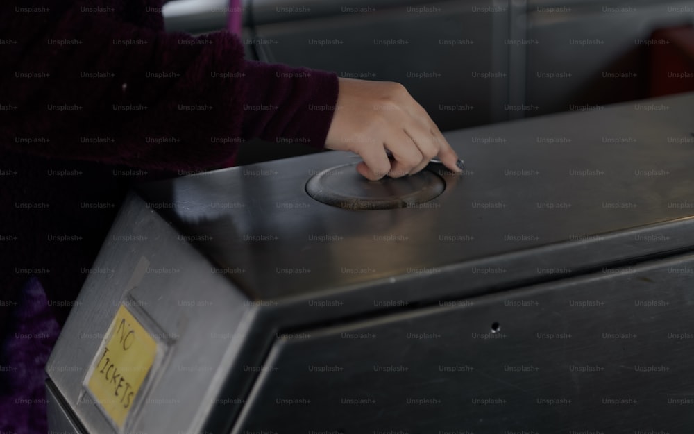 una persona che preme un pulsante su un forno a microonde