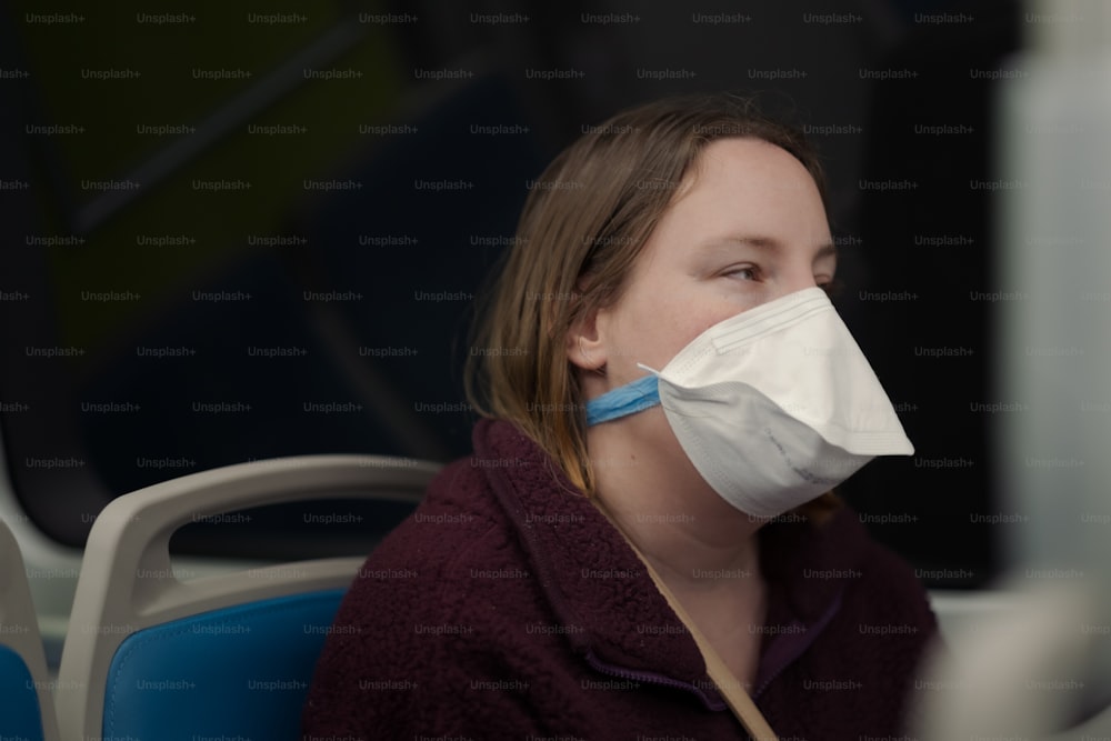 uma mulher usando uma máscara facial em um ônibus