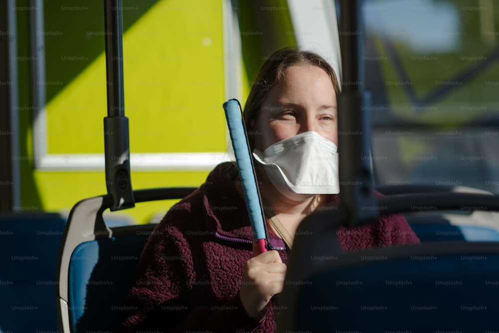 a woman wearing a face mask on a bus