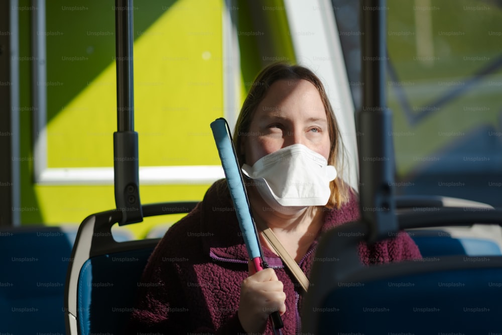 uma mulher usando uma máscara facial em um ônibus