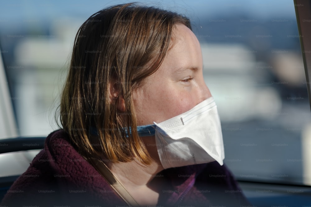 a woman in a car wearing a face mask