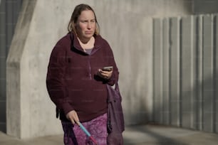 a woman walking down the street with a cell phone in her hand