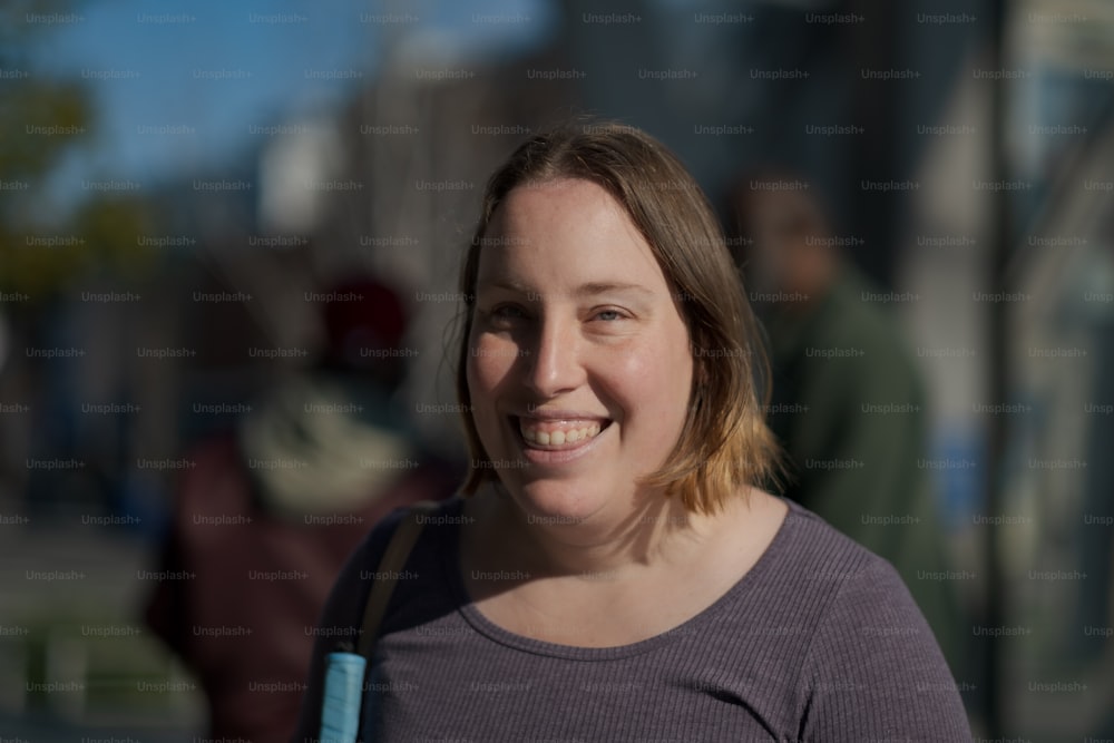 a smiling woman with a blue book in her hand